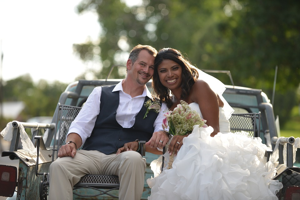 bride and groom in the back of pickup truck