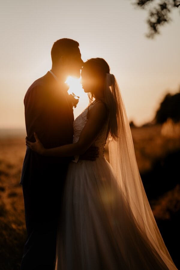 man and woman kissing during sunset