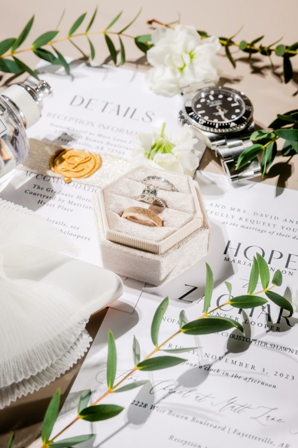 a table topped with a ring box and flowers