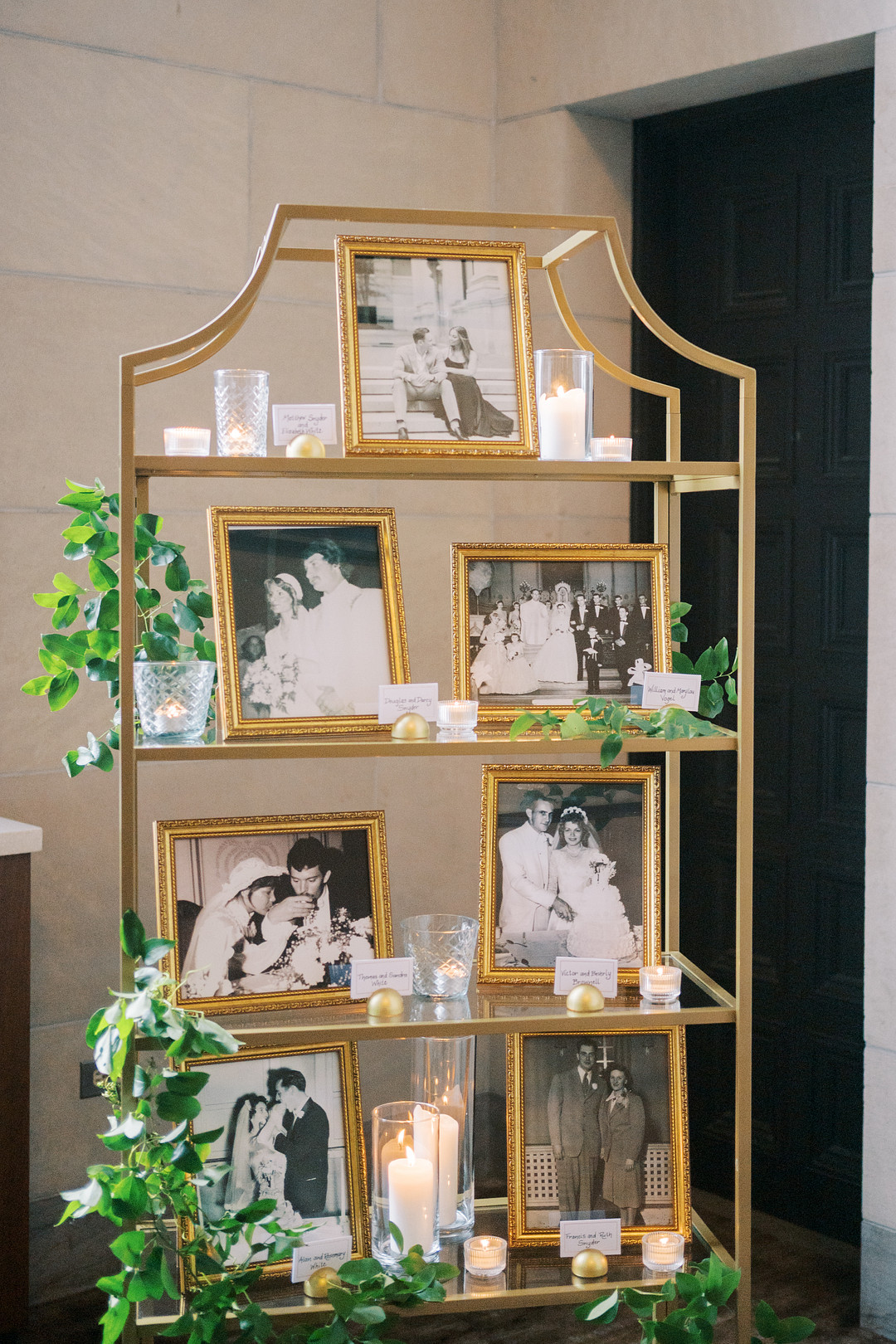 Gold shelves with framed photos and white flowers