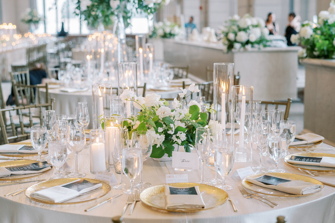 Reception tables with candles, white flowers and gold chargers