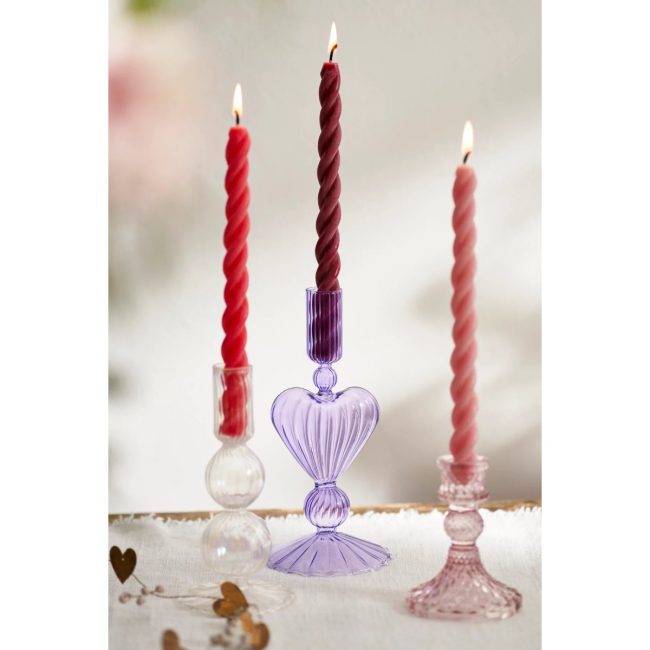 Three Anthropologie twisted taper candles in red, burgundy and pink in glass candlesticks