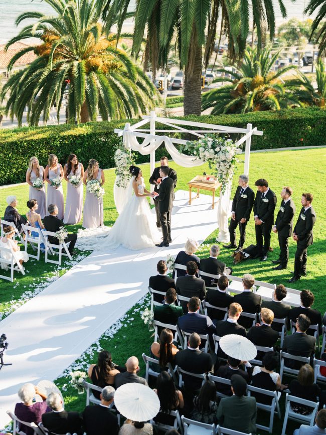 Oceanfront wedding ceremony framed by palm trees at Bel-Air Bay Club