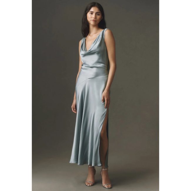 Model in the BHLDN Aurora cowl-neck satin maxi slip dress in pale blue with a side slit