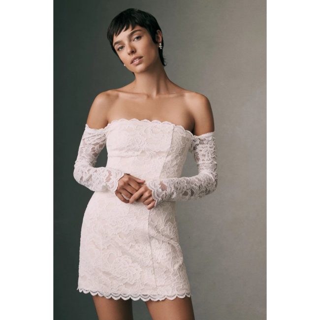 Model in the BHLDN off-the-shoulder lace mini dress in blush with long lace sleeves