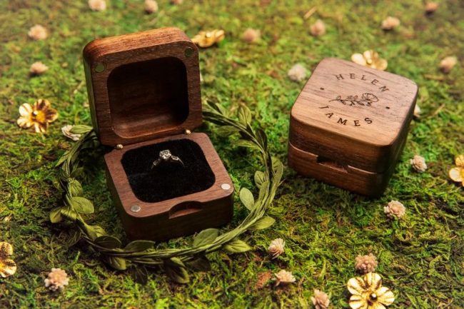 BurrowLeather walnut ring boxes on moss, one open with an engagement ring and one engraved with names