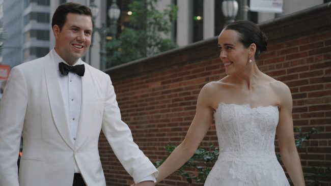 Bride and groom walking hand in hand along brick walls in Los Angeles