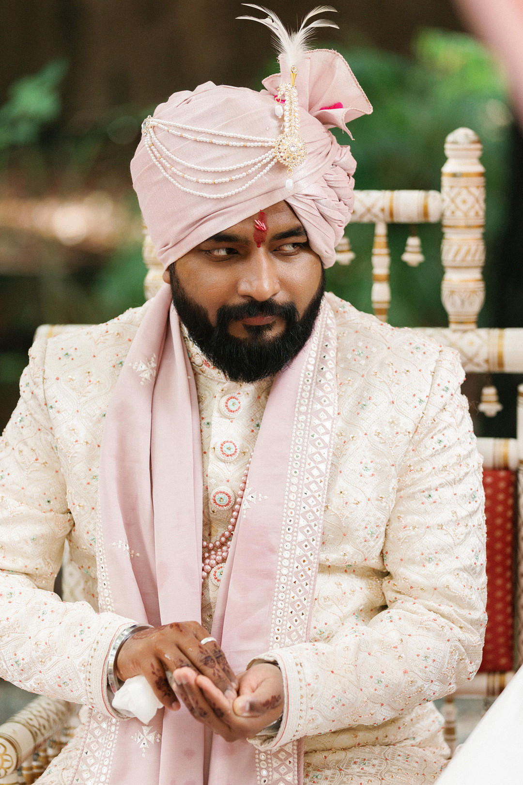 Groom in a blush turban and ivory sherwani
