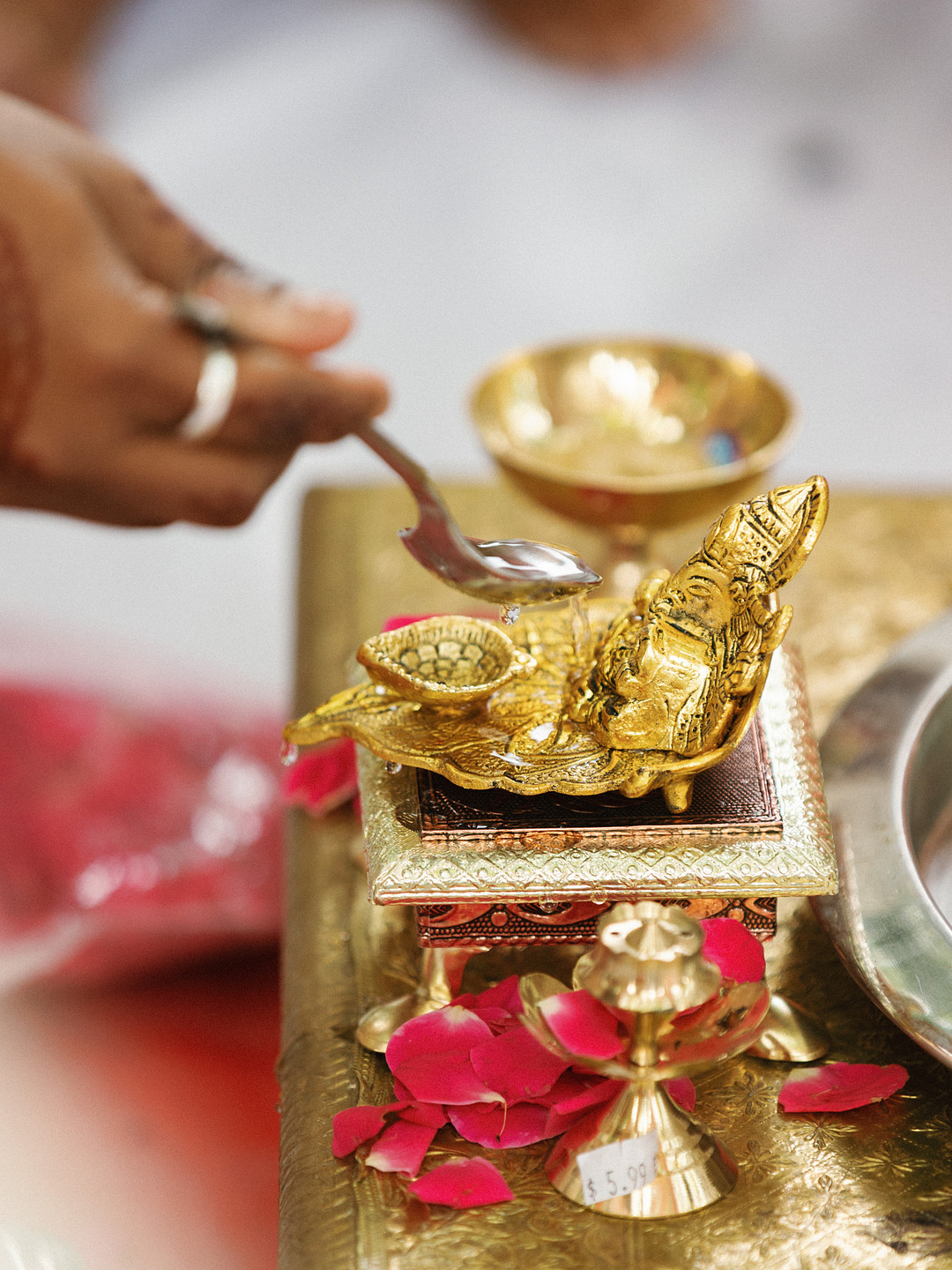 Brass ceremony items and flowers on the mandap table