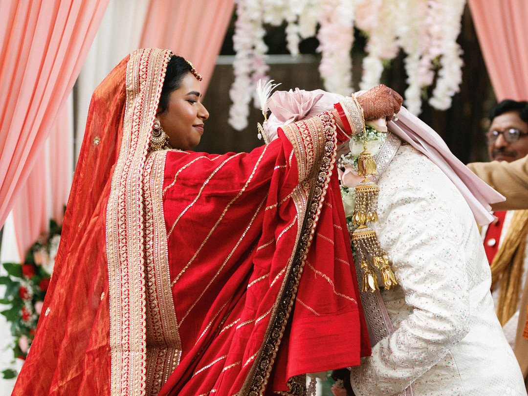 Bride placing a flower garland on the groom