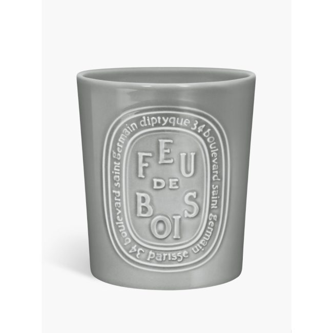Diptyque Feu de Bois large candle in a gray glass vessel with the scent name in an oval