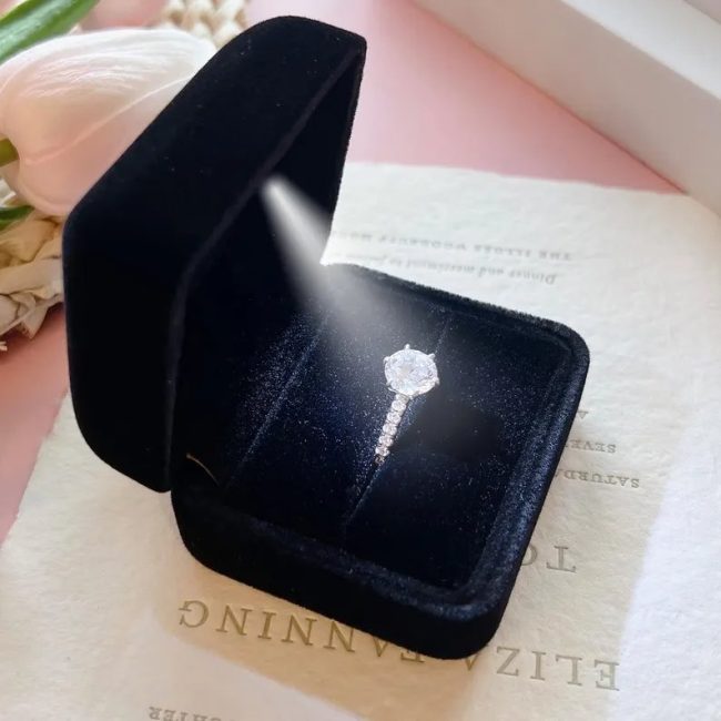 FLORENCEBOX black velvet ring box with a built-in light shining on a diamond ring