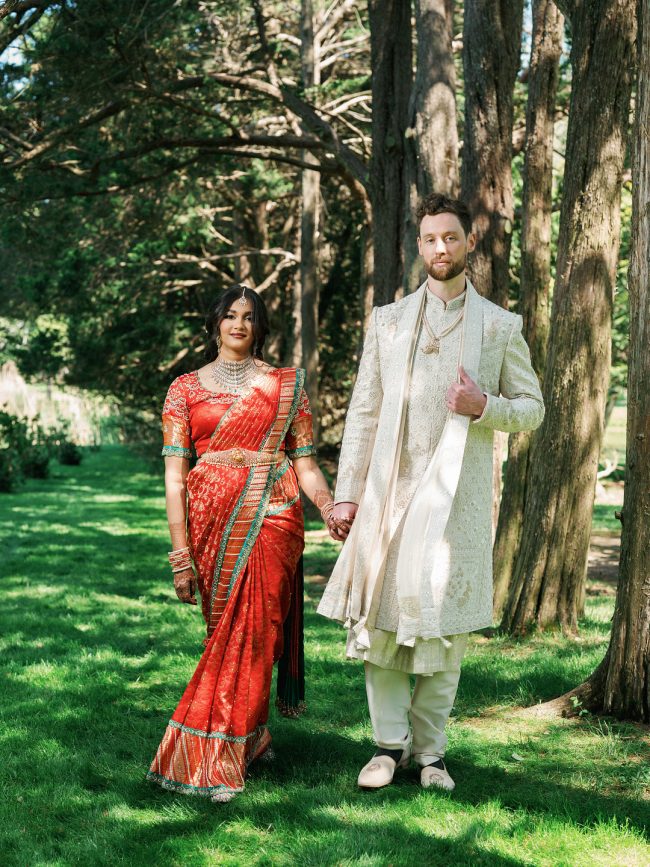 Bride and groom walking through the trees at Flowerfield in St. James, New York