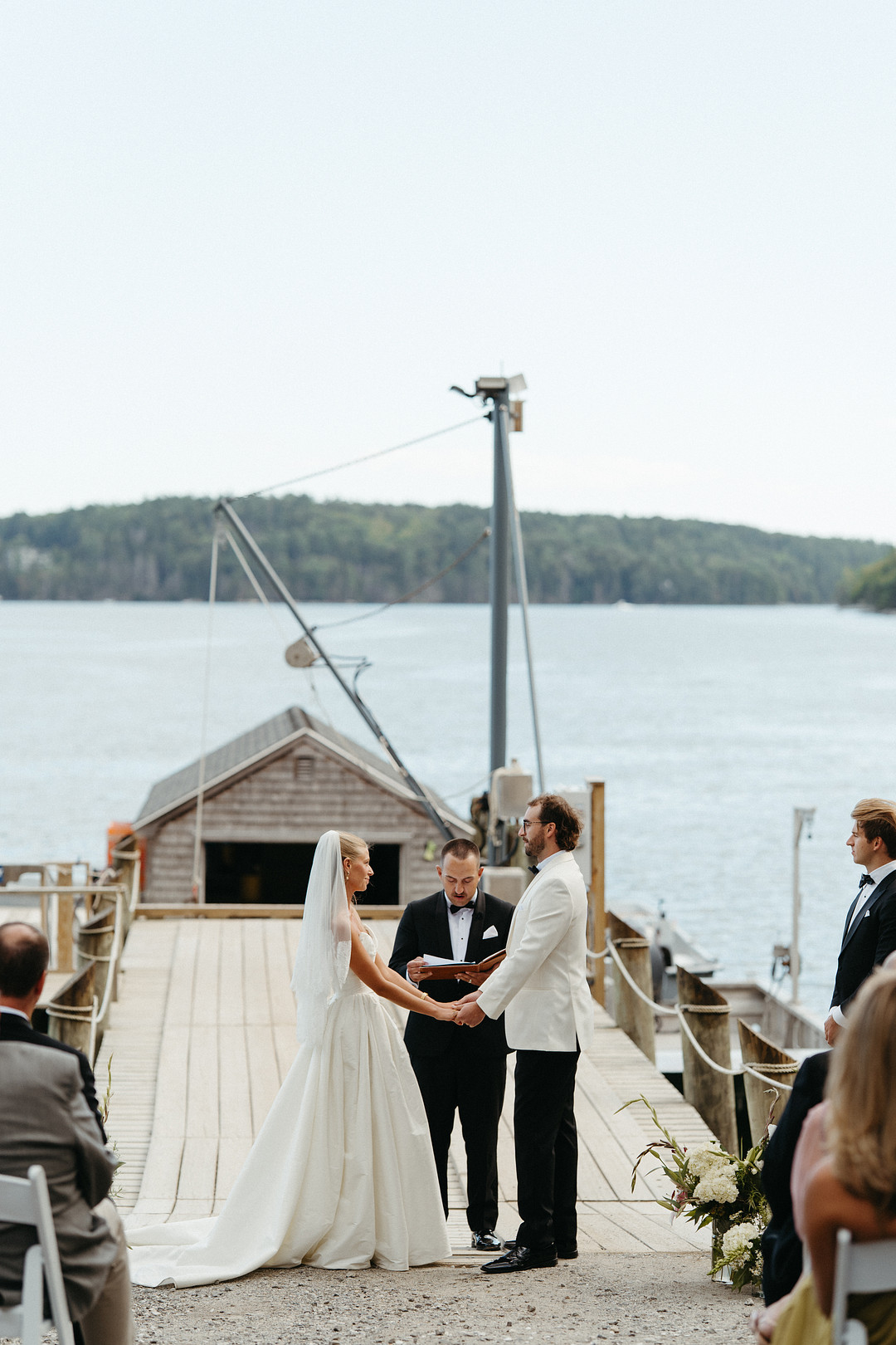 Bride and groom exchanging vows on the working dock at Glidden Point