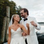 Bride and groom laughing together by the water