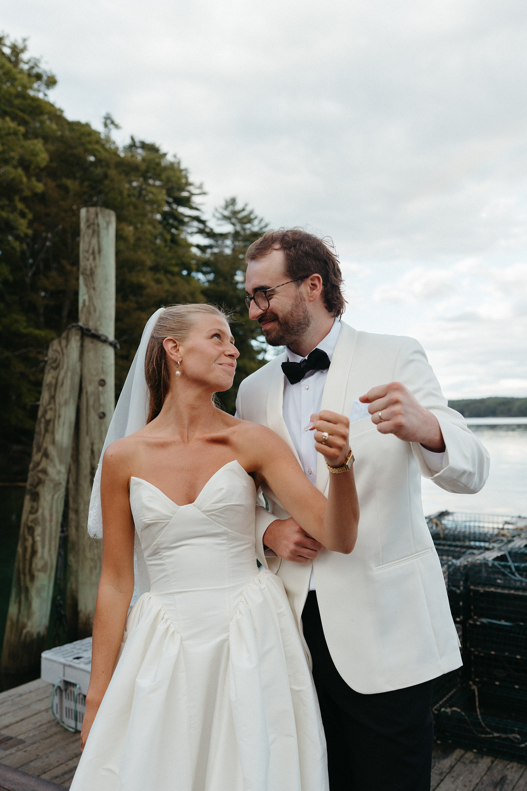 Bride and groom laughing together by the water