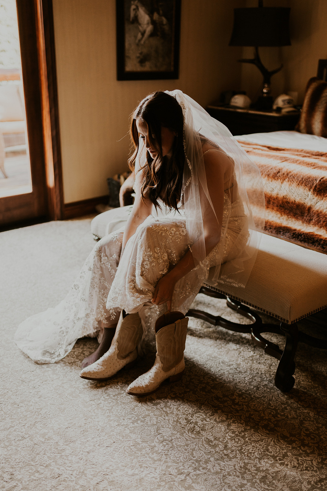 Bride pulling on white cowboy boots