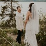 Bride and groom at their first look on the shore of Jackson Lake with the Tetons behind them