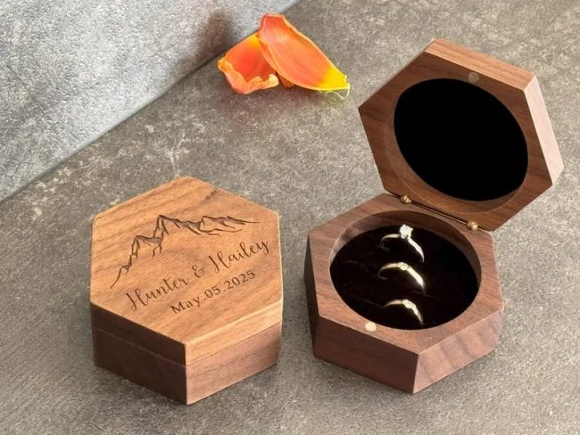 GriffinGoCreative hexagon walnut ring boxes, one engraved Hunter and Hailey with mountains and one open with three rings