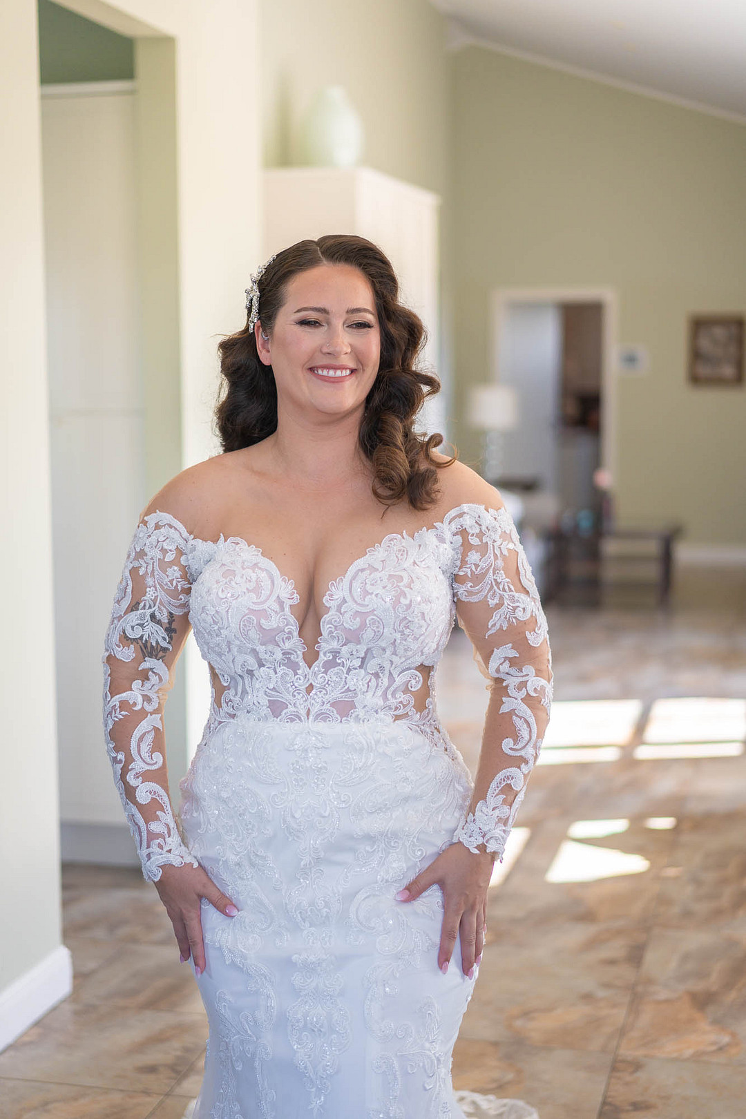 Smiling in a long-sleeve lace gown before the ceremony