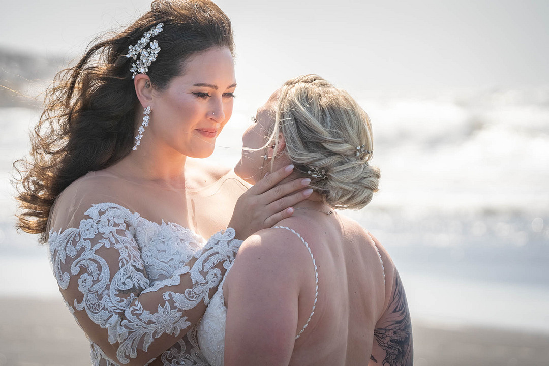 The couple touching foreheads on the beach