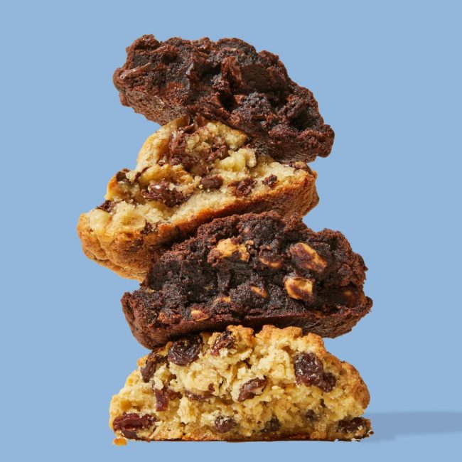 Stack of oversized Levain Bakery cookies on a blue background