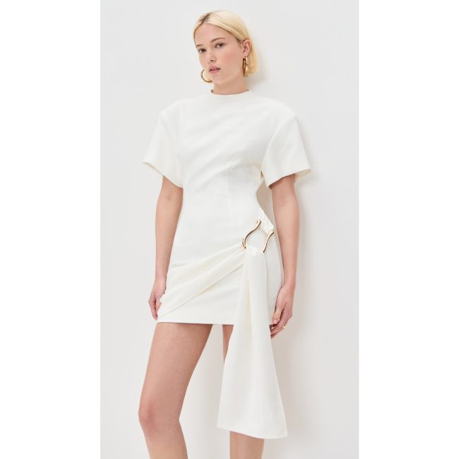 Model in the white Lioness Martini mini dress with short sleeves and a draped side tie with a ring detail