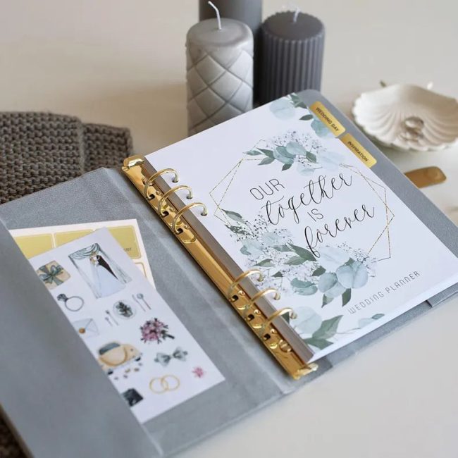 Lsite linen ring-bound wedding planner open to a floral divider and planning pages