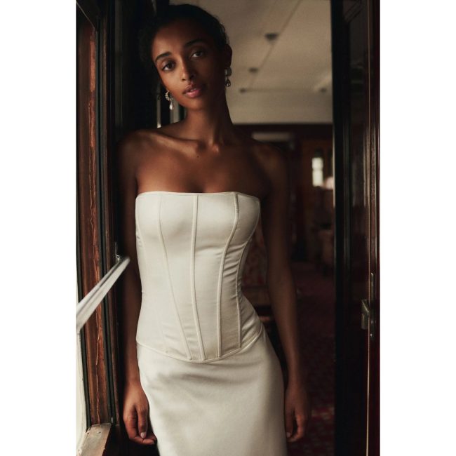 Model in the Mare Mare ivory satin set with a strapless corset top and a matching skirt