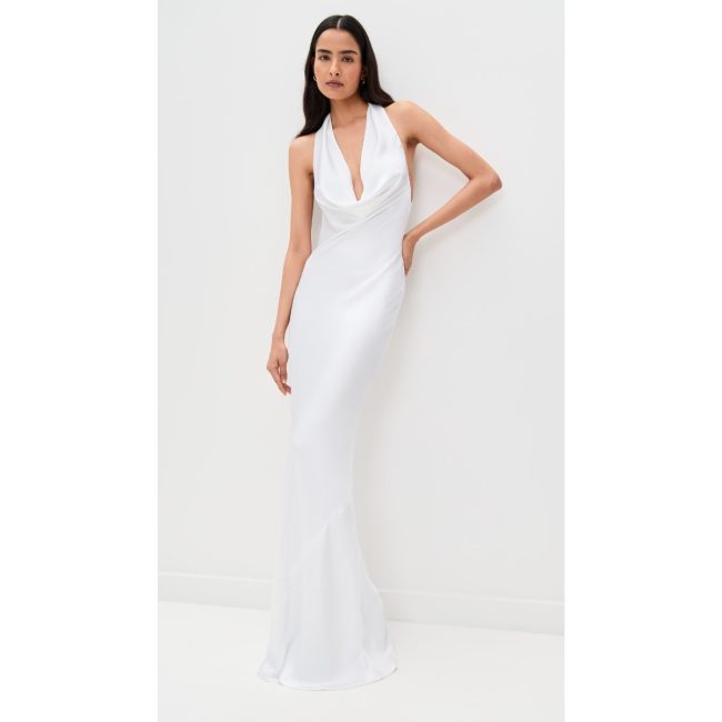 Model in the white Norma Kamali halter bias-cut gown with a draped neckline