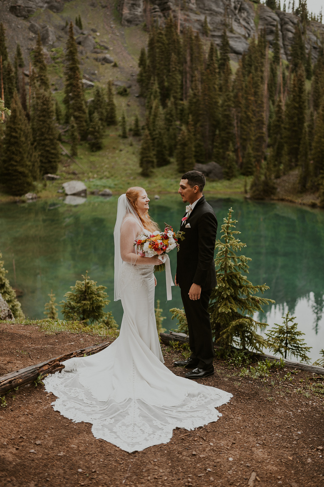 Bride and groom on the shore of a turquoise alpine lake