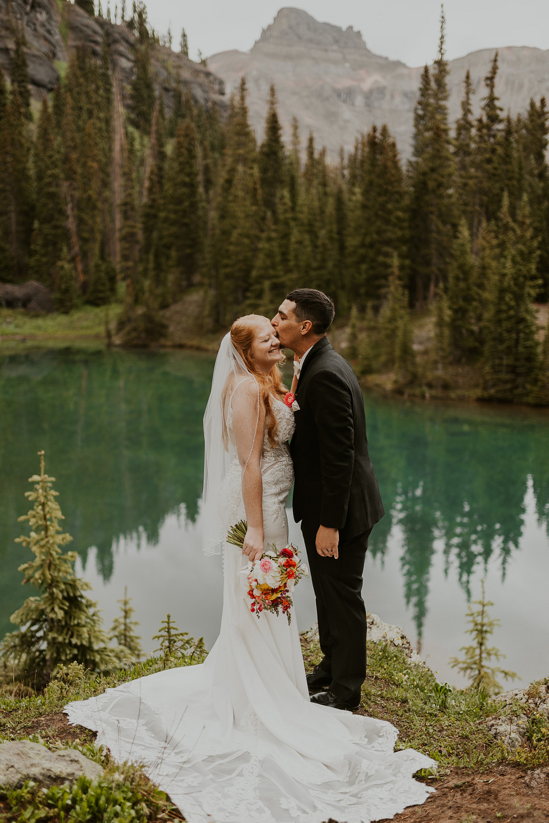 Bride and groom kissing at the lakeshore