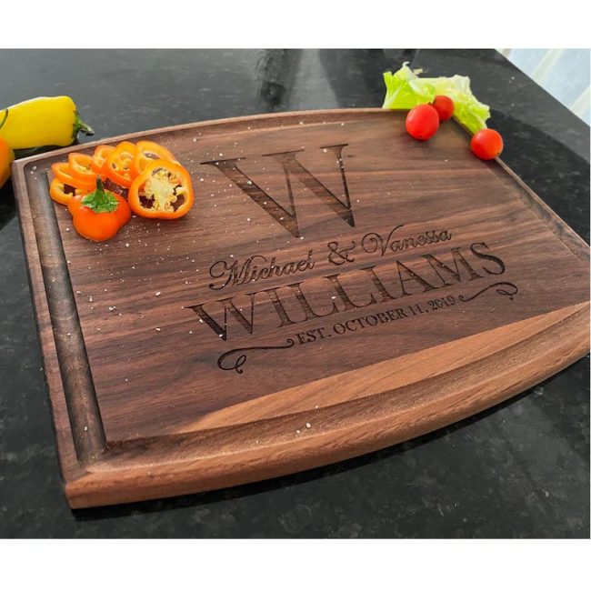 Walnut cutting board engraved with a large W monogram, the couple's first names, the surname Williams and an established date