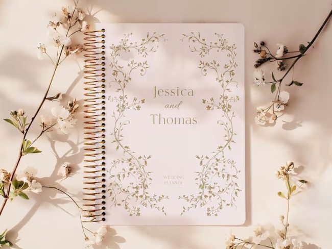 posypaper spiral wedding planner with a floral line frame and two names on a blush cover