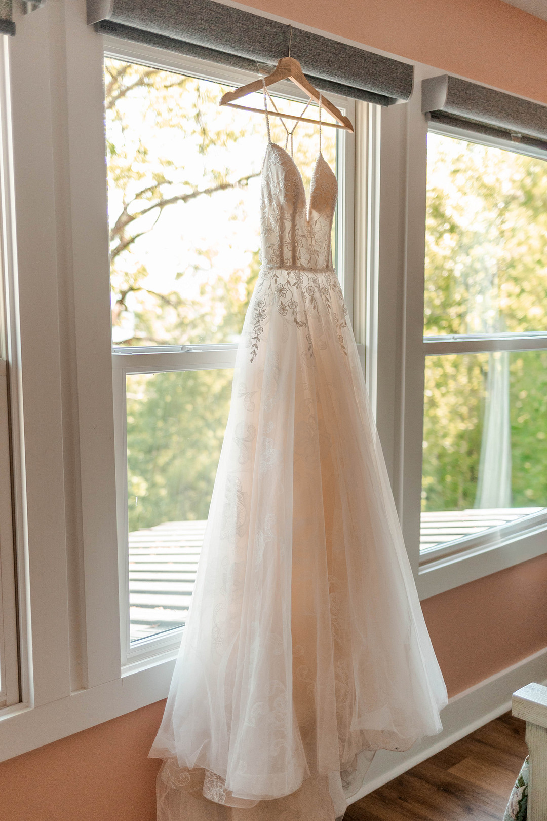 Wedding gown with a tulle skirt hanging in a cabin window at ReTreet