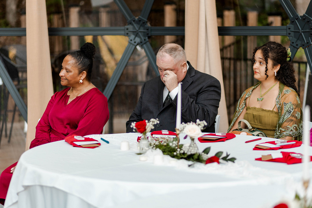 Guests watching the ceremony from a table set with red napkins
