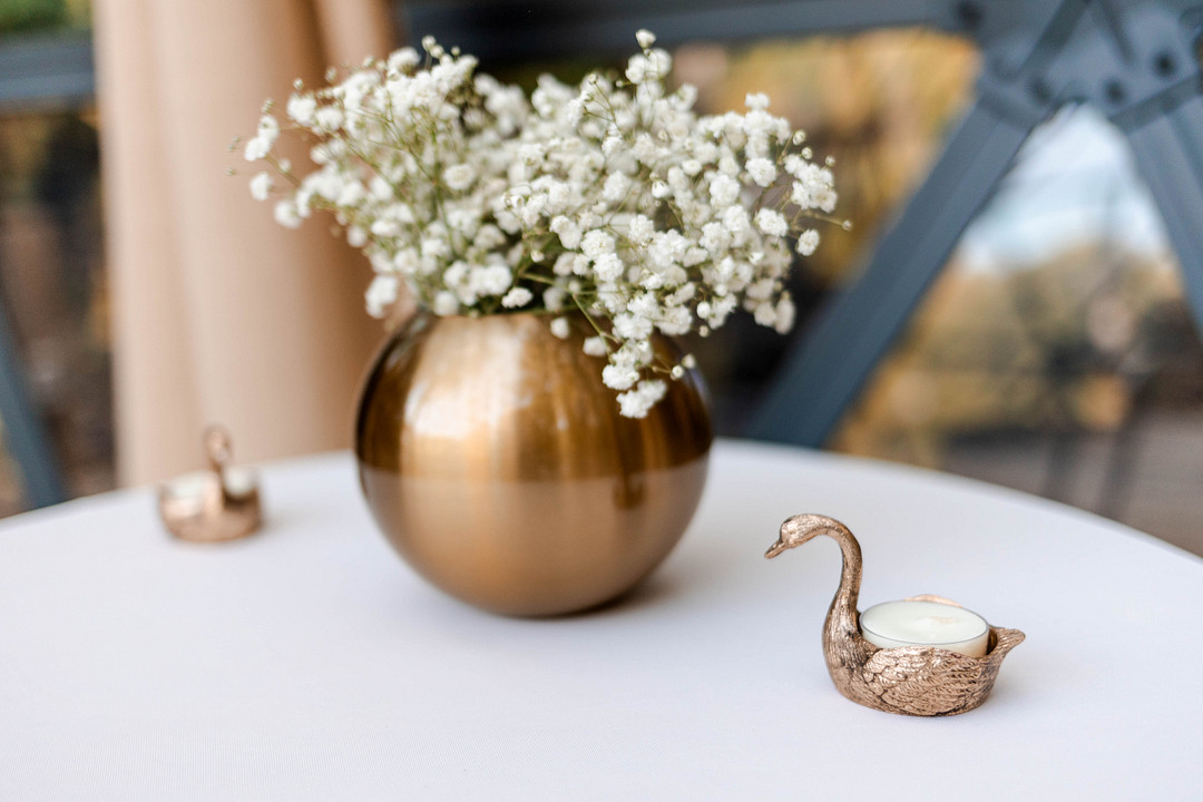 Gold vase of baby's breath on a white reception table
