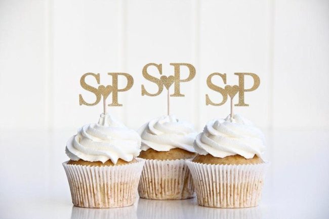 Three white frosted cupcakes with shoppaperandparties gold glitter monogram toppers
