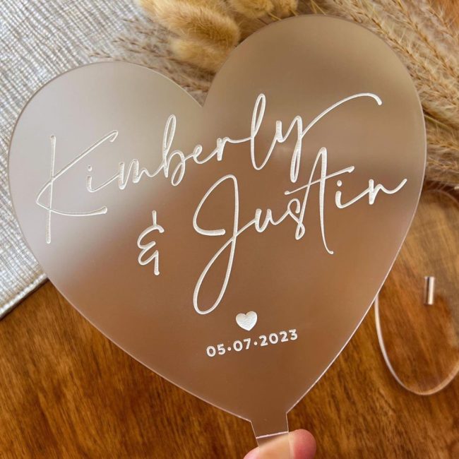 TaylorStreetFavors frosted acrylic heart cake topper with Kimberly and Justin and a date in white script