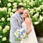 Bride and groom among white hydrangeas