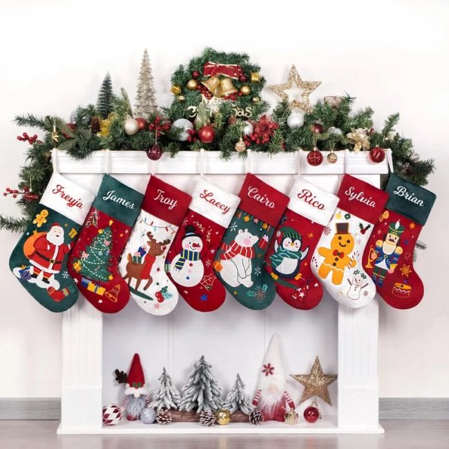 TwinsDesignStudio velvet Christmas stockings embroidered with names, hung on a white mantel