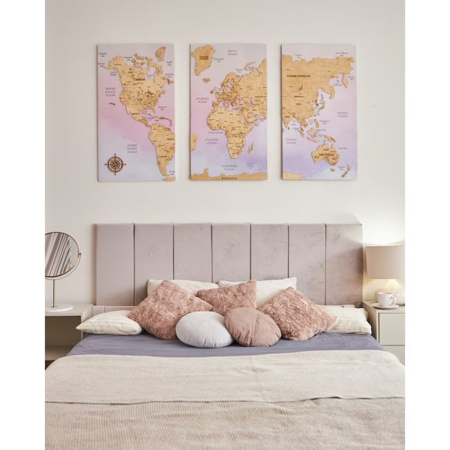 Three-panel wooden push pin world map with pastel backgrounds hanging on a wall above a bed